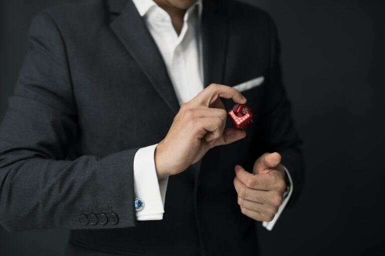 A businessman elegantly dressed in a suit holding a fidget cube, symbolizing stress management.